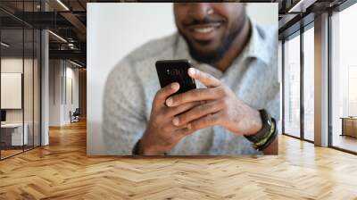 Close up of smiling biracial man using modern smartphone gadget Wall mural