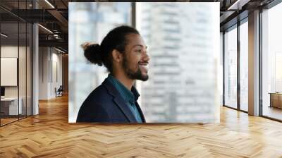 Close up of smiling young African American businessman in suit look in window distance thinking dreaming of career success. Happy male employee or boss make plans decisions. Business vision concept. Wall mural