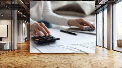 Close up of woman busy paying bills online on computer calculating household finances or taxes on machine, female manage home family expenditures, using calculator, make payment on laptop Wall mural