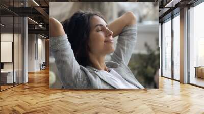 Close up of young Caucasian woman rest hands over head daydream or visualize relieve negative emotions. Happy calm millennial female relax with eyes close, meditate or sleep. Stress free concept. Wall mural