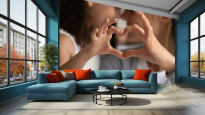 Close up of young mother and cute little daughter make heart sign with hands enjoy close tender moment together, caring mom and grateful small girl child show love and support in family relationships Wall mural