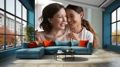 Close up overjoyed middle aged mother and grownup daughter cuddling, enjoying tender moment, leisure time, excited young woman touching mature mum shoulders, good family relationship, two generations Wall mural