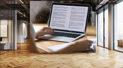 Close up view of modern technology digital gadget opened computer with electronic documents on screen. Young woman preparing report or reading scientific article, studying at home, education concept. Wall mural