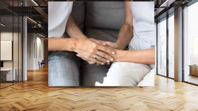 Close up view of young woman daughter holding old mother female hands as concept of different older and younger generations support, giving love and care to senior people, helping elderly parents Wall mural