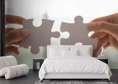 Close up view two female hands holding pieces join puzzles having fun play game. Connecting jigsaw, finding best match right solution, help in business, bond and mental connection, brain work concept Wall mural