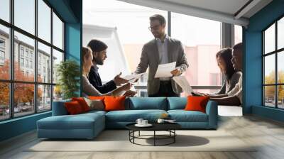 Confident businessman manager giving documents to colleague, presenting financial report Wall mural