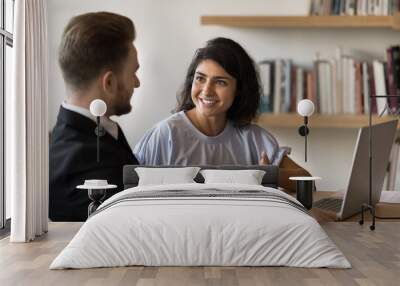 Confident male businessman listening to positive inspired smiling young Indian manager woman. Two diverse business colleagues brainstorming on project strategy, teamwork, shaking creative ideas Wall mural