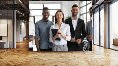 Corporate portrait successful smiling diverse employees team standing in office, posing for photo with confident businesswoman team leader executive, looking at camera, unity and cooperation Wall mural