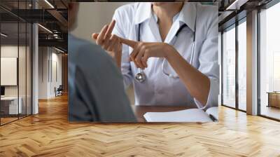 Crop close up of woman doctor prescribe treatment to senior male patient at meeting in hospital. Female GP or therapist talk consult mature man in clinic. Elderly healthcare, geriatrics concept. Wall mural