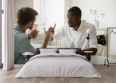 Dissatisfied African American worker arguing with Caucasian colleague, showing disagreement with contract breach issue, discussing document content, trying to prove his point of view. Bad relations Wall mural