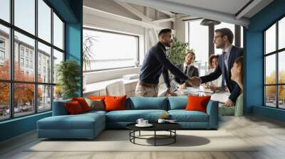 Diverse business partners shaking hand in modern boardroom after negotiation, signing contract, making successful deal, Arabian executive greeting new employee at meeting, group negotiations Wall mural