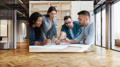 Diverse employees colleagues working with project statistics, financial documents together, sitting at table in modern boardroom, brainstorming at briefing, coworkers group engaged in teamwork Wall mural