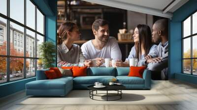 Diverse young people meeting in cafe drinking coffee Wall mural