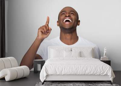 Excited laughing African American man pointing finger up Wall mural