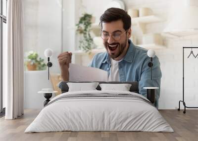 Excited man reading postal mail letter overjoyed by good news Wall mural