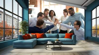 excited multiracial colleagues give high five involved in teambuilding activity at meeting, happy di Wall mural