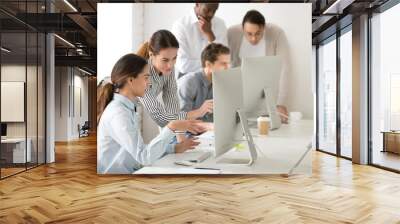 Executive mentor explaining intern or new employee online task pointing at computer screen, female boss supervisor teaching young girl to use corporate software or helping with difficult assignment Wall mural