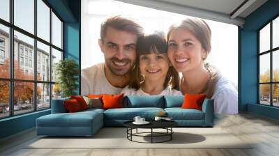 Family portrait of happy parent posing with little daughter Wall mural