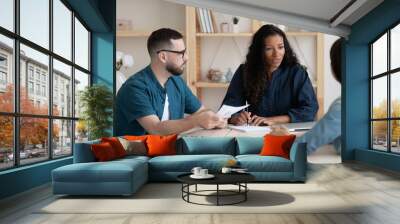 Focused young african american female supervisor holding meeting with teammates. Wall mural