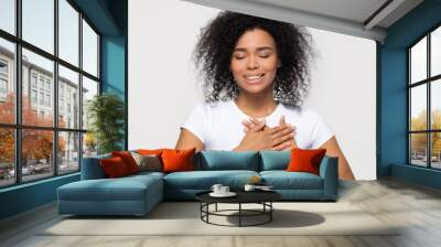 Grateful happy black woman holding hands on chest feeling thankful Wall mural