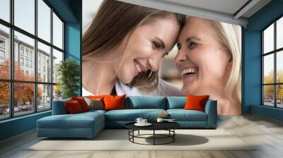 Grown up daughter cuddle old 60s mama happy excited women laughing seated on sofa in living room. Family bond, care and love concept. Horizontal photo close up banner for website header design concept Wall mural