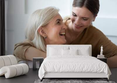 Grownup daughter hugging senior mom showing love and care Wall mural