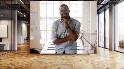 Happy african american businessman standing in modern office, business portrait Wall mural