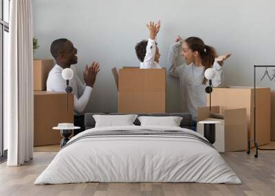 Happy African American family playing with boxes in new apartment Wall mural