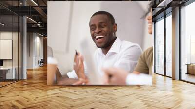 Happy african businessman laughing talking working together with friendly colleagues Wall mural