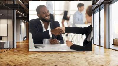 Happy african manager broker handshaking caucasian client at meeting Wall mural