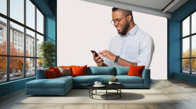 Happy black man using smartphone get pleasant message Wall mural