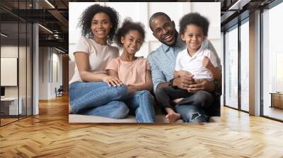 Happy cute black family of four portrait. Wall mural