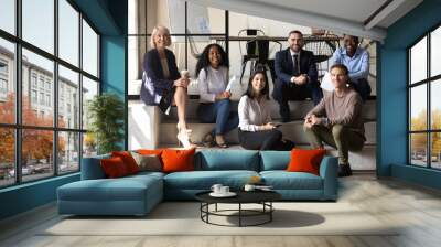 Happy diverse business team people sit on stairs in office Wall mural