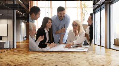 Happy diverse business team talking brainstorming gathered at table Wall mural