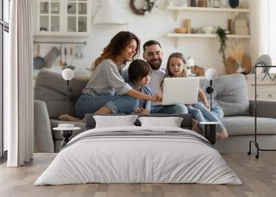 Happy family with kids sit on couch using laptop Wall mural