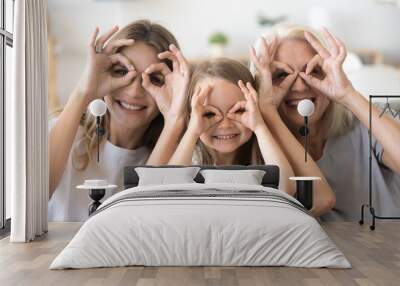 Happy kid granddaughter, mother and grandmother having fun portrait, cheerful 3 generations women family smiling making funny faces looking at camera, grandma, mom and child grimacing together Wall mural