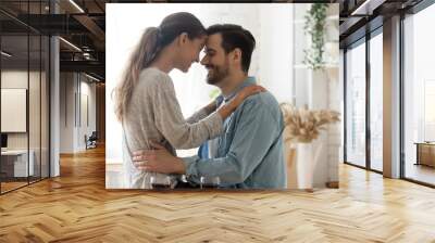 Happy loving mixed race couple enjoying sweet moment in kitchen. Wall mural