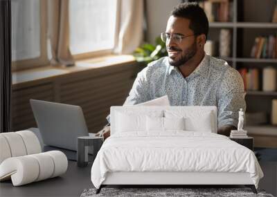 Happy millennial african american businessman in eyewear doing paperwork. Wall mural