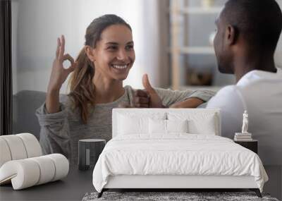 Happy mixed race deaf couple using sign language for communication Wall mural