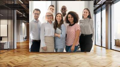 Happy multicultural work team looking at camera posing in office Wall mural