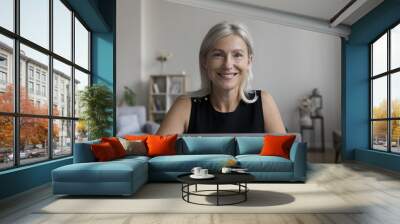 Happy pretty freelance business woman home portrait. Cheerful confident senior professional lady working on successful project, sitting at laptop computer, looking at camera, smiling Wall mural