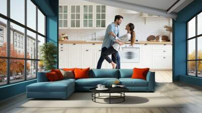 Happy romantic couple dancing in modern kitchen at home Wall mural