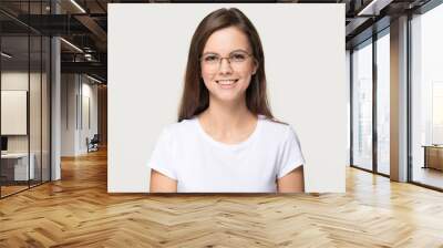 Happy teen girl student in glasses isolated on grey background Wall mural