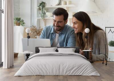 Happy young couple paying bills online in computer app Wall mural