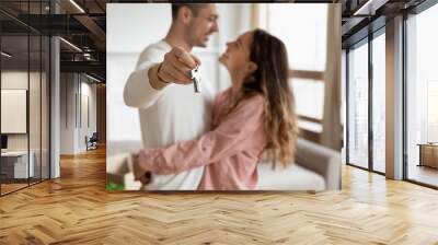 Happy young couple show house keys moving together Wall mural