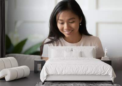 Head shot asian young woman sit on couch holding pregnancy test smiling see positive two stripes result. Planned pregnancy, healthy female, ovulation period, modern device for detect gestation concept Wall mural