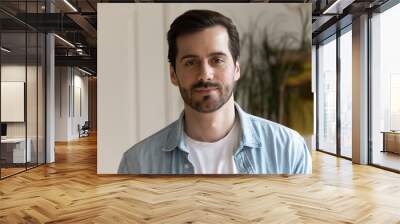 Head shot confident handsome bearded man looking at camera, posing for profile picture, standing at home, serious focused male making video call, using webcam, distance job interview, online study Wall mural