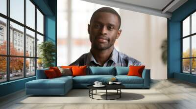 Head shot of confident young handsome black man looking at camera. Portrait African American single bachelor male standing posing in living room at home. Successful millennial wellbeing person concept Wall mural