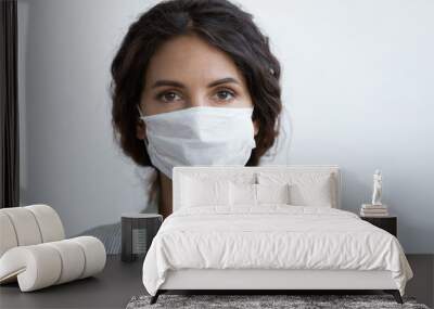 Head shot portrait attractive woman looking at camera wear medical or surgical blue colour face mask protecting from COVID19 or corona virus. Personal care during pandemic infectious disease outbreak Wall mural