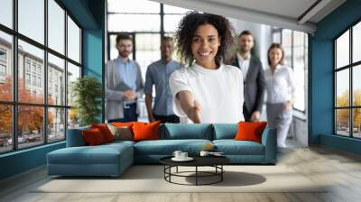 Head shot portrait smiling African American businesswoman offering handshake, standing with extended hand in modern office, friendly hr manager or team leader greeting or welcoming new worker Wall mural